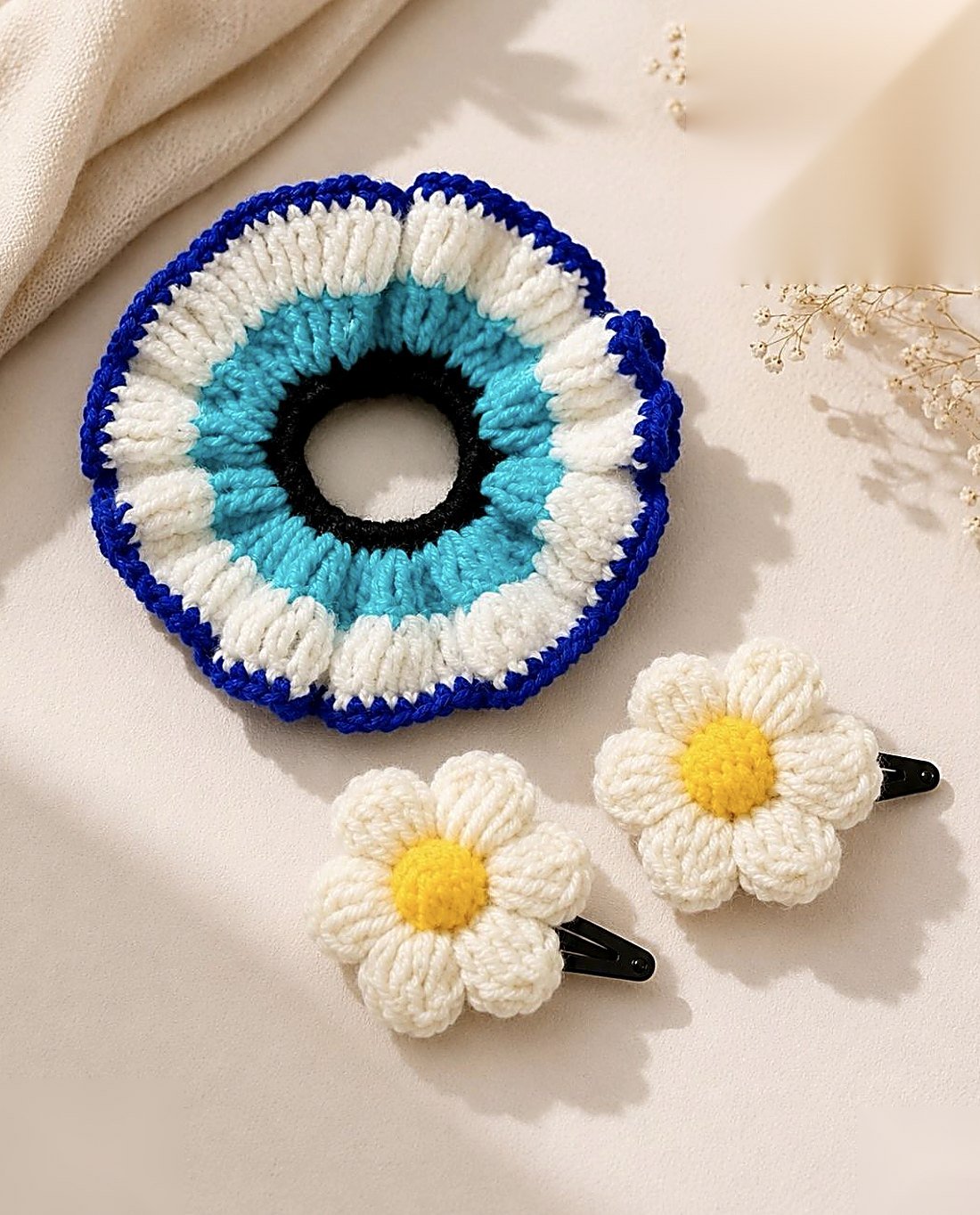 A crochet nazar scrunchie with daisy clips