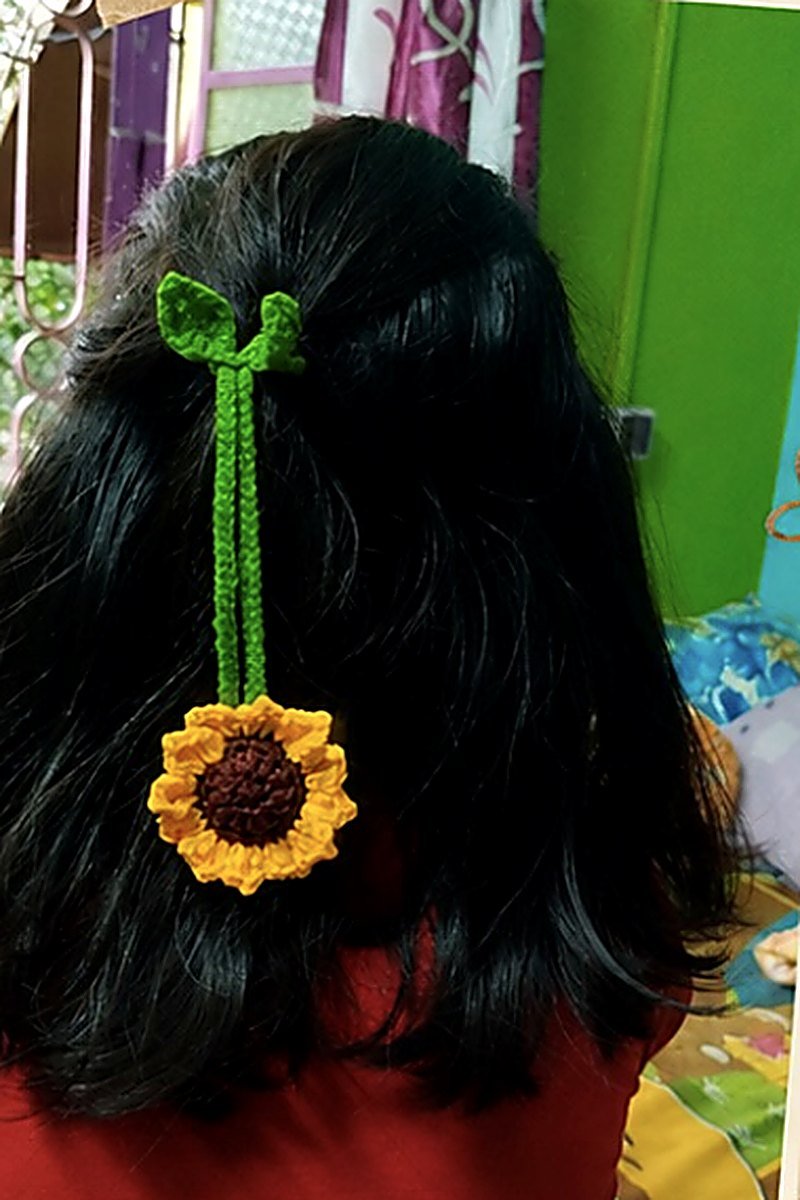 A sunflower charm tied into hair